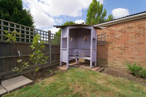 a purple outhouse in a yard next to a fence at Rydal Palace Rugby - Charming 2Bed Haven With Free Driveway Parking in Rugby