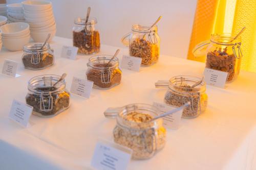 a table filled with jars of food with labels at Felix Hotels - Hotel La Baja in Santa Caterina