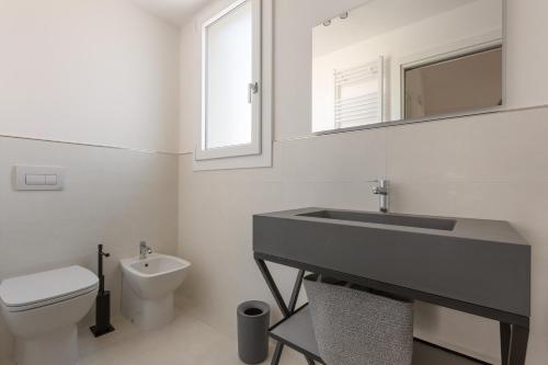 a bathroom with a sink and a toilet and a mirror at Amate' by BarbarHouse in Ruffano