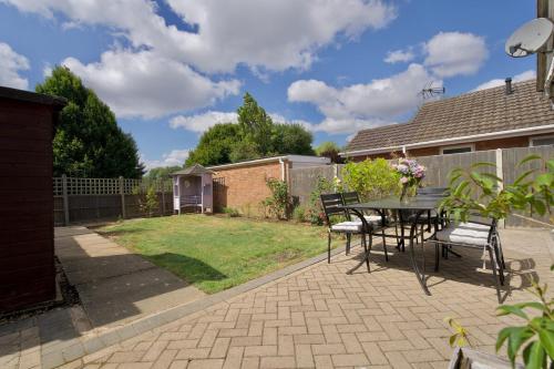 a patio with a table and chairs in a backyard at Rydal Palace Rugby - Charming 2Bed Haven With Free Driveway Parking in Rugby