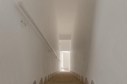 a hallway with a white wall and a window at Amate' by BarbarHouse in Ruffano