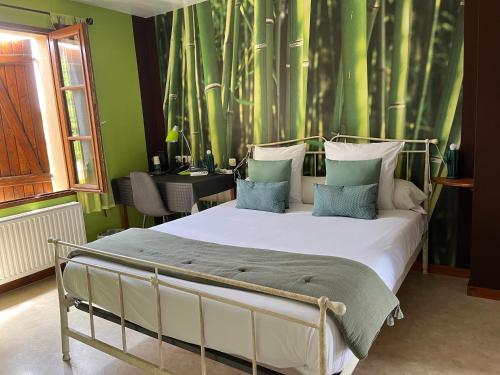 une chambre avec un grand lit aux murs verts dans l'établissement Logis hôtel Les Confins du perche, à Sceaux-sur-Huisne