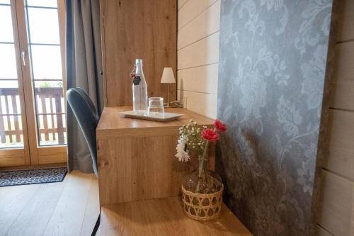 a desk with a bottle of wine and flowers on it at Hotel Aletsch in Bettmeralp