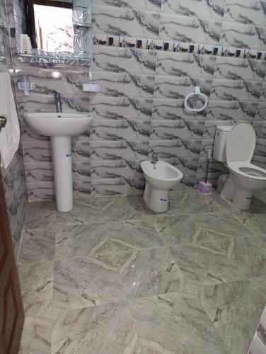 a stone bathroom with two toilets and a sink at فيلا بمولاي بوسلهام in Kenitra