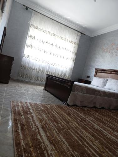 a bedroom with a bed and a large window at فيلا بمولاي بوسلهام in Kenitra