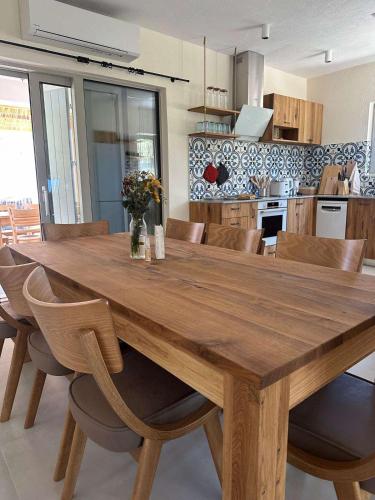 a wooden dining table and chairs in a kitchen at Villa Afroditi, Skiathos, Kalivia, Greece in Skiathos National Airport