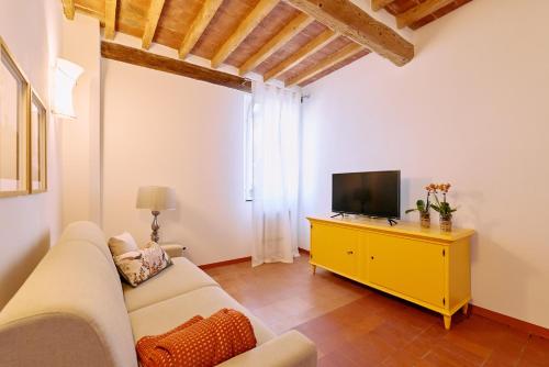 un soggiorno con un divano bianco e una televisione di Casa Lippa a Spilamberto