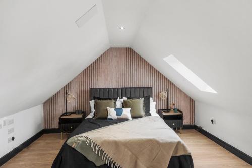 a bedroom with a bed and two night stands at 7 Bed Coastal Villa - Private Heated Pool, Sauna, Parking in Filey