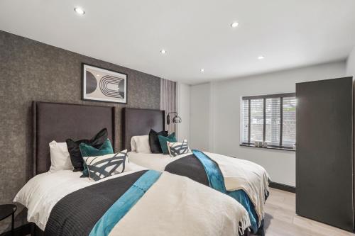 a bedroom with two beds and a window at 7 Bed Coastal Villa - Private Heated Pool, Sauna, Parking in Filey