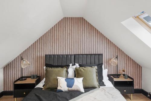 a bedroom with a large bed with a wooden headboard at 7 Bed Coastal Villa - Private Heated Pool, Sauna, Parking in Filey