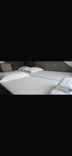 a close up of a bed with white sheets and pillows at Artion Suites Nikiti in Nikiti