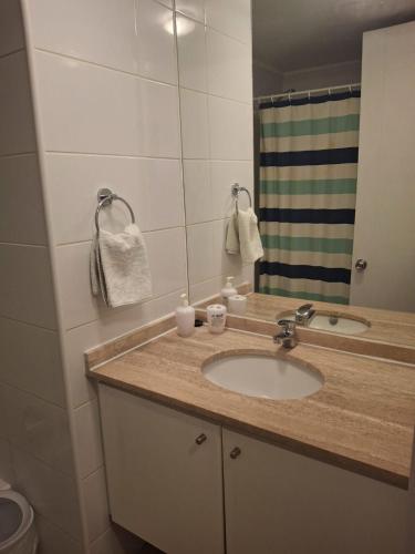 a bathroom with a sink and a mirror at Condominio en el Centro de Calama in Calama