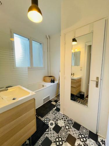 a bathroom with a tub and a sink and a mirror at Jean Jaurès - Centre Ville in Brest
