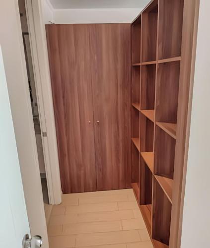 a closet with wooden shelves and a door at Condominio en el Centro de Calama in Calama