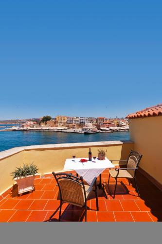 a table and chairs on a patio with a view of the water at Casa Leone Hotel in Chania Town