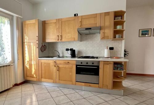 een keuken met houten kasten en een fornuis bij Civico 20, Quiet Cozy Studio Air Condition in Mandello del Lario