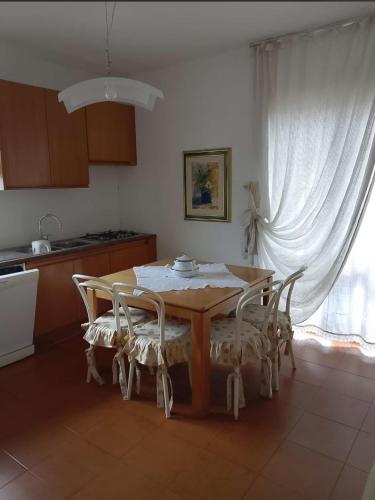 a kitchen with a wooden table with chairs and a window at Al piccolo principe in Cles