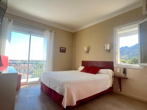 une chambre avec un lit et une grande fenêtre dans l'établissement Saint Jacques, à Sorède