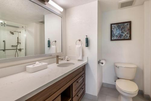 a bathroom with a toilet and a sink and a mirror at Orbit One Vacation Villas in Orlando