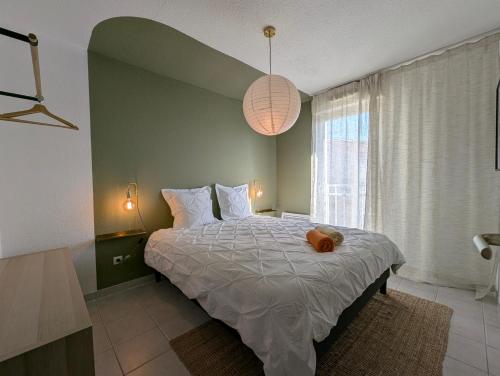 une chambre avec un lit avec un animal en peluche dessus dans l'établissement Le Belvédère - Clim Terrasse Parking privé, à Balaruc-les-Bains