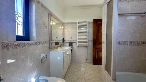 a bathroom with a sink and a mirror and a tub at Atanasio by Check-in Portugal in Albufeira