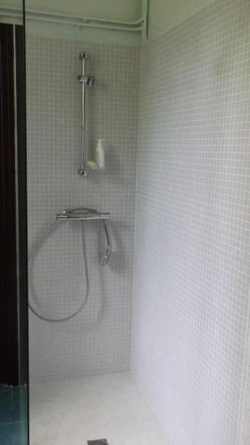 una doccia in un bagno con pareti piastrellate bianche di Large charming property a Saint-Yrieix-la-Perche