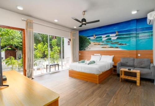 een slaapkamer met een bed en een schilderij aan de muur bij Ocean Villa Ukulhas Hotel & Spa in Ukulhas