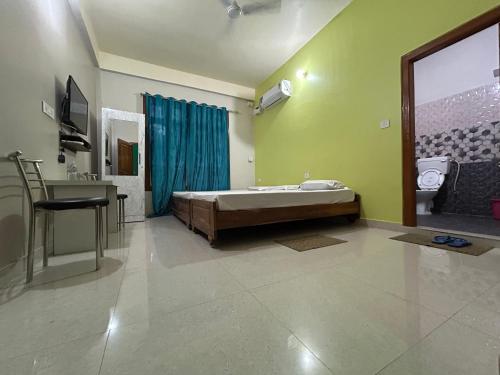 a bedroom with a bed and a desk and a sink at Kaziranga Balaji Homestay in Kāziranga