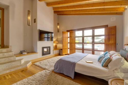 une chambre avec un grand lit et une cheminée dans l'établissement Exclusive Palma Villa with Modern Amenities, 1001, à Calvià