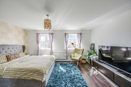 ダートフォードにあるLondon Suburb Home Sleeps 7 - Great Connectionsのベッドと薄型テレビのある寝室