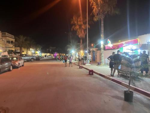 a city street at night with people walking on the street at Dar Hella Apartments in El Maamoura