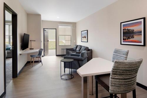 a living room with a couch and a table and chairs at ClubHouse Hotel & Suites Rapid City in Rapid City