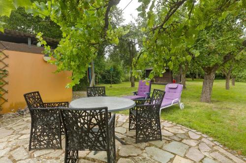 a patio with a table and chairs under a tree at Ferienwohnung Ruhepol, 75qm in Vellmar