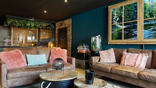 a living room with two couches and a table at Le Theux Toit - Escapade romantique et Wellness in Theux
