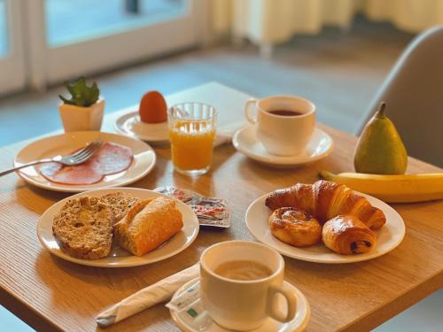 een tafel met borden ontbijtproducten en kopjes koffie bij Saint Jacques in Sorède