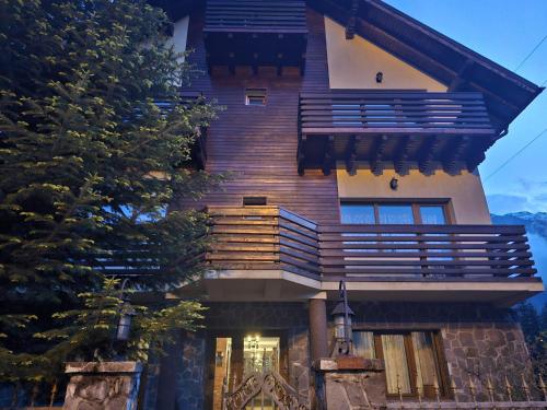 ein großes Haus mit einem Balkon an der Seite in der Unterkunft Casa Yna in Buşteni