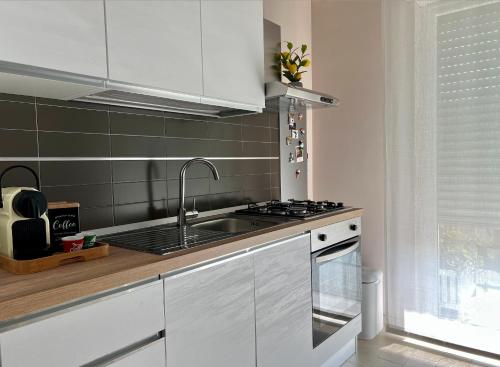a kitchen with white cabinets and a sink at Roseto Marina Vista Monte in Roseto degli Abruzzi