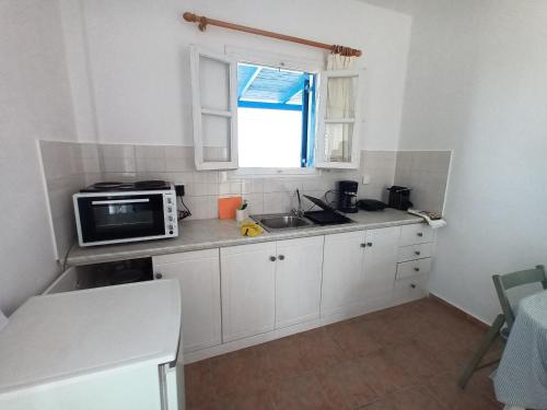 a small kitchen with a sink and a microwave at Evdokia 4 in Koufonisia