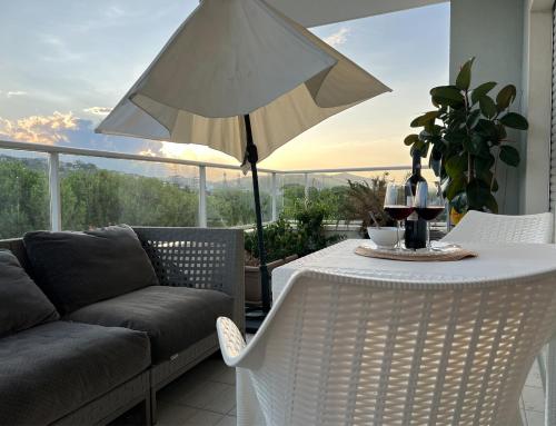 a patio with a table and a white umbrella at Roseto Marina Vista Monte in Roseto degli Abruzzi