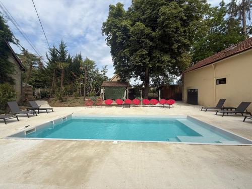 une grande piscine avec des chaises et une table dans l'établissement Domaine de la Belvaudière - 22 Pers - Piscine - Luxe -Rêve au Mans, à Saint-Pavace