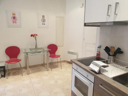 a kitchen with two red chairs and a table at Quiet flat center Monaco in Monte Carlo