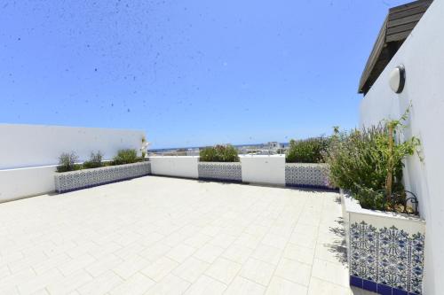 a patio with plants on a white wall at Dar Hella Apartments in El Maamoura