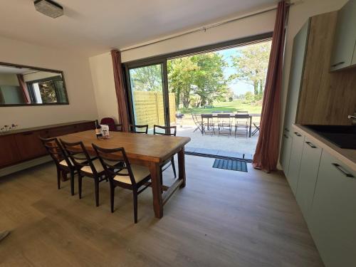 una cucina e una sala da pranzo con tavolo e sedie di charmante maison a 300 m de la plage et du GR 34 a Landéda
