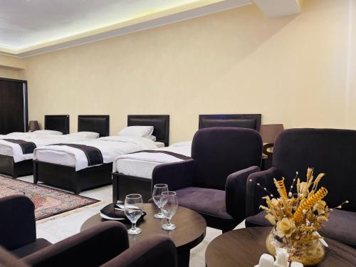 a hotel room with two beds and chairs and a table at Kabul Taj Hotel in Kabul