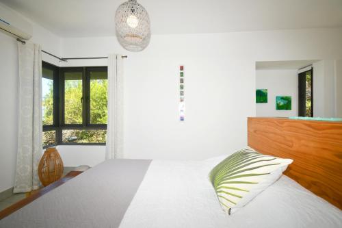 Un dormitorio con una cama blanca con cabecero de madera. en Le Bergamote, en Riambel