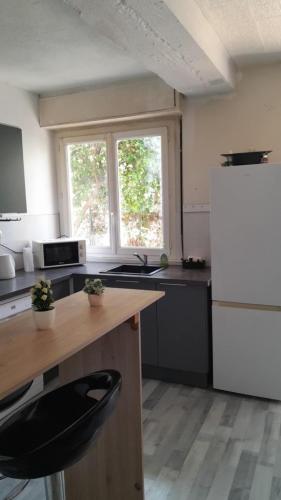a kitchen with a white refrigerator and a black counter top at T3 quartier des Baléares in Perpignan