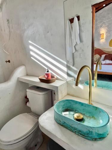 a bathroom with a sink and a toilet at Zema Bangalôs in Trairi