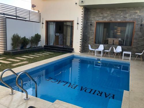 a swimming pool in a villa with a house at Farida Habu Palace Hotel luxor in Al Aqālitah
