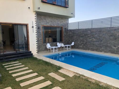 a swimming pool in the backyard of a house at Farida Habu Palace Hotel luxor in Al Aqālitah