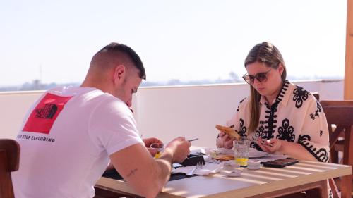 a man and a woman sitting at a table eating food at Farida Habu Palace Hotel luxor in Al Aqālitah